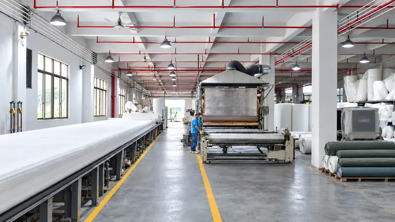 Filter media processing equipment and rolls of material in a workshop